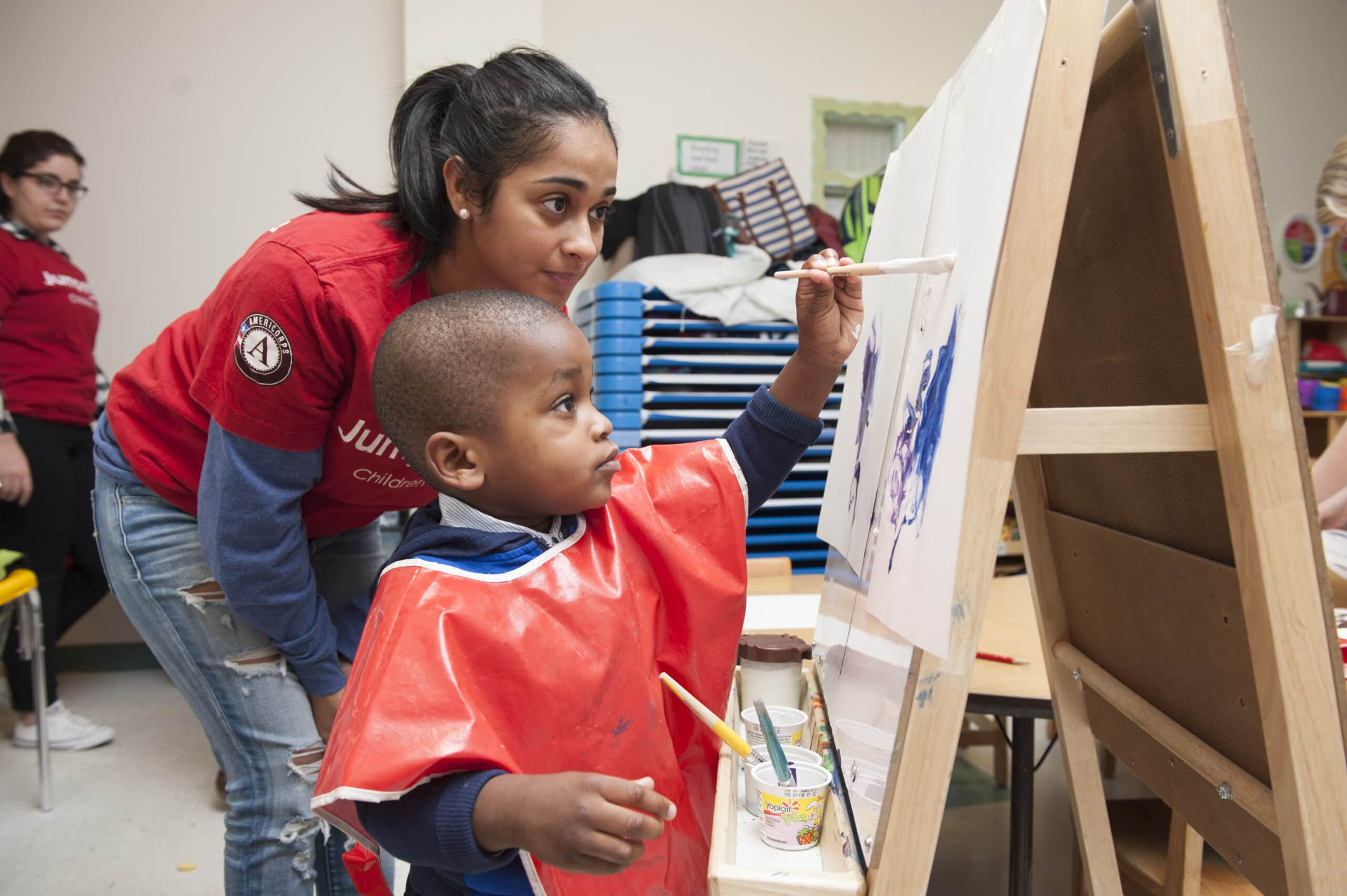 Jumpstart Volunteer and child painting. Photo Courtesy of: Jumpstart