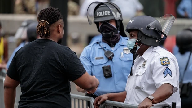 Police and pretester shaking hands