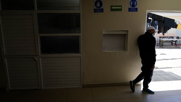 A man waits at a shelter for migrants