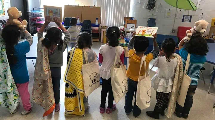 Children receive “Night Night” tote bags. Photo Courtesy of: Project Night Night. 