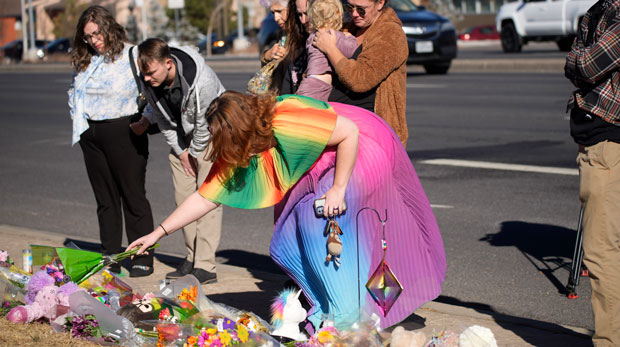Amanda Kirkbird of Colorado Springs, Colo., leaves flowers at a makeshift display of bouquets of flowers on a corner near the site of a mass shooting at a gay bar Monday, Nov. 21, 2022, in Colorado Springs, Colo. (AP Photo/David Zalubowski)