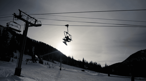 Skiers ride a lift