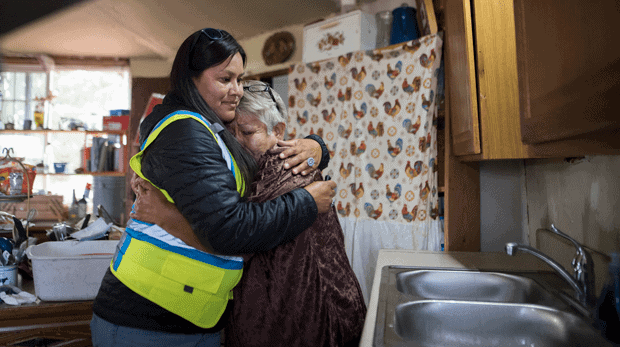 Shanna Yazzie, project manager for the Navajo Mountain team of DigDeep's Navajo Water Project, left, hugs a client at a home in October 2022